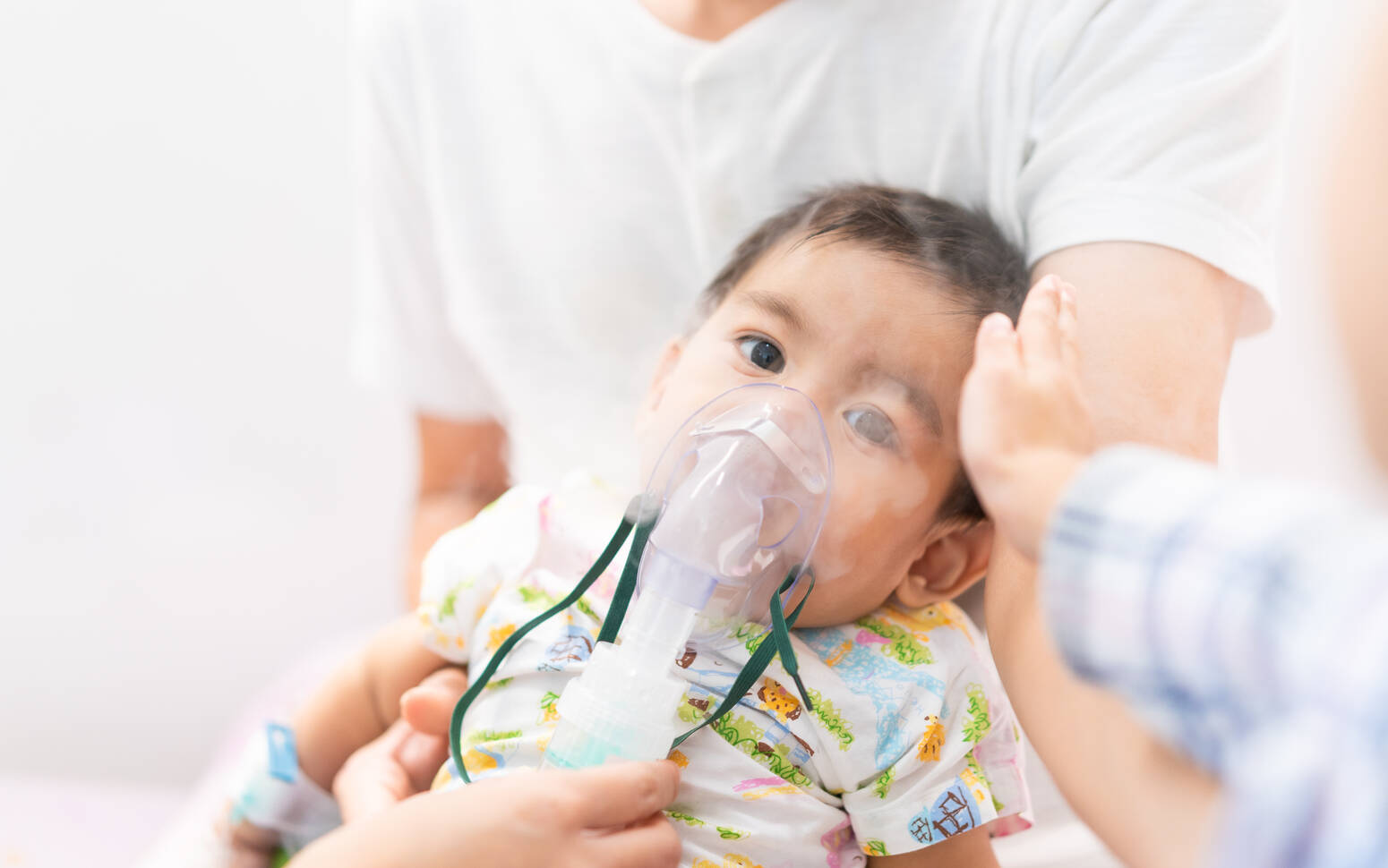 baby sitting with breathing mask