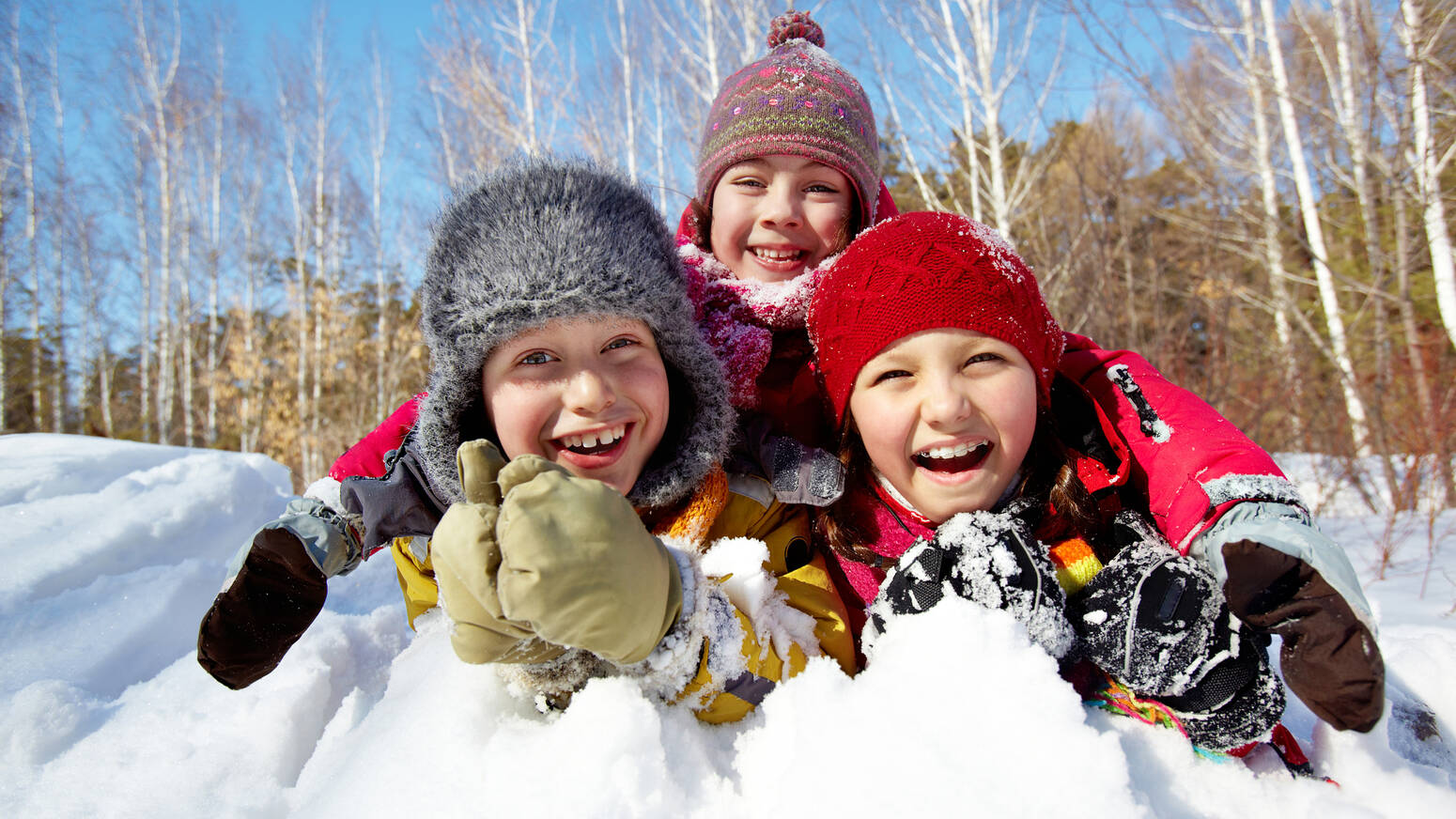 three kids play in snow