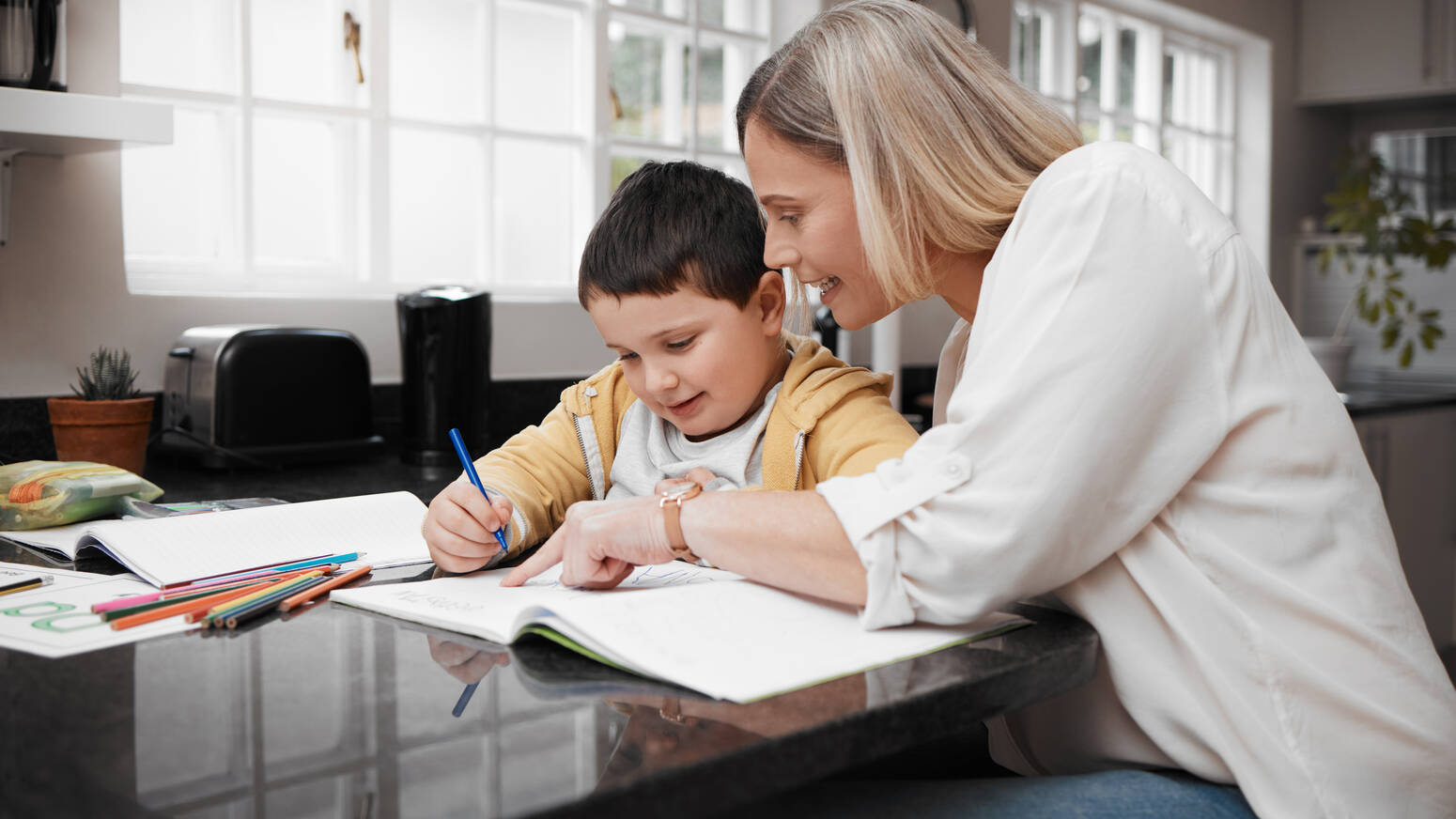 mom and son sitting at table doing schoolwork