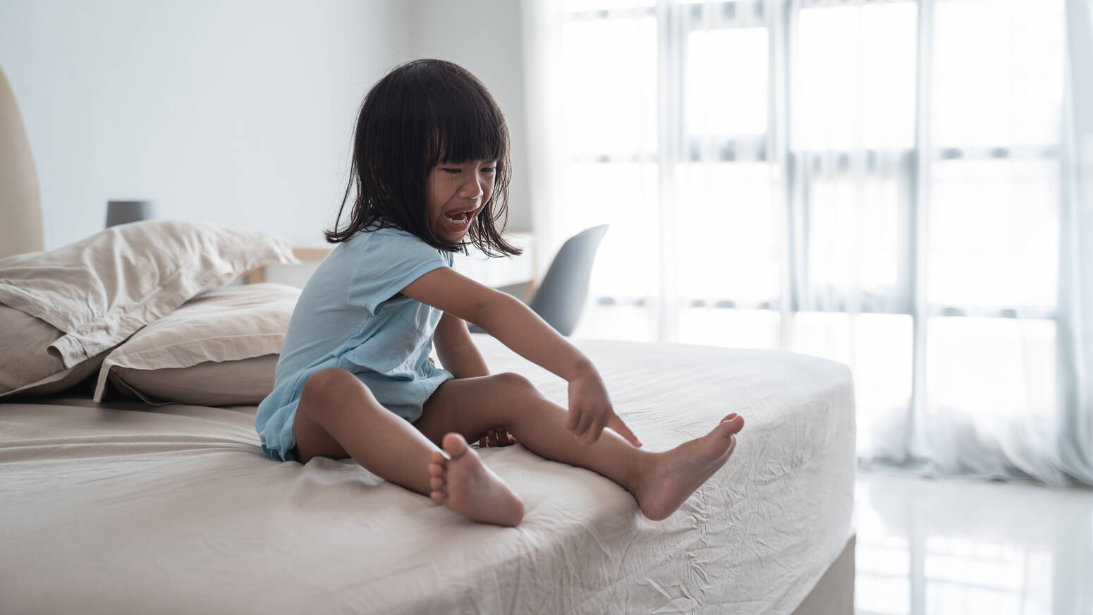 girl on bed throwing tantrum