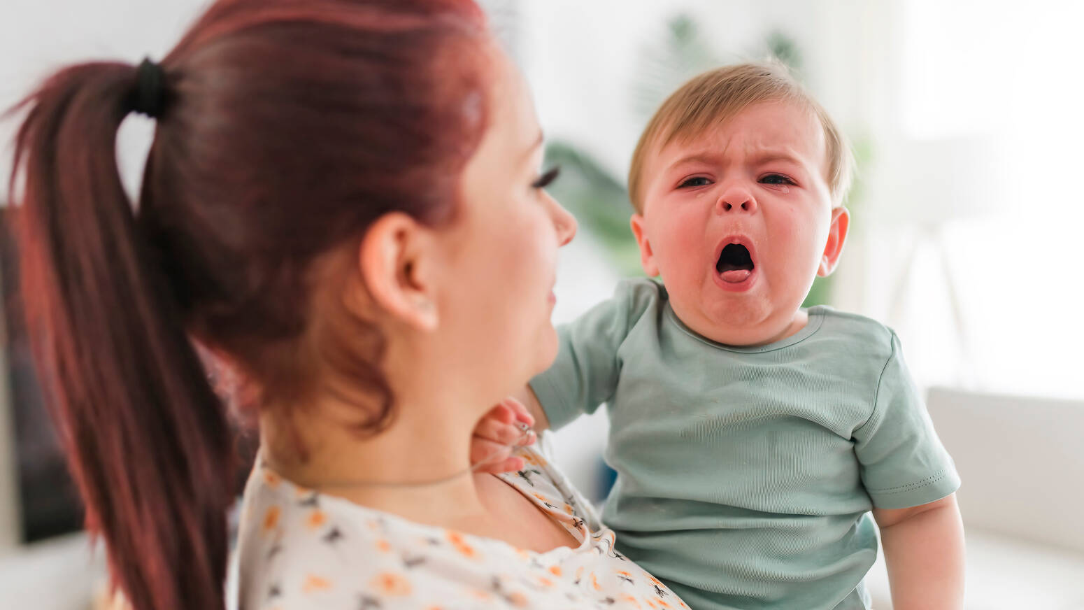 mom holding baby boy coughing