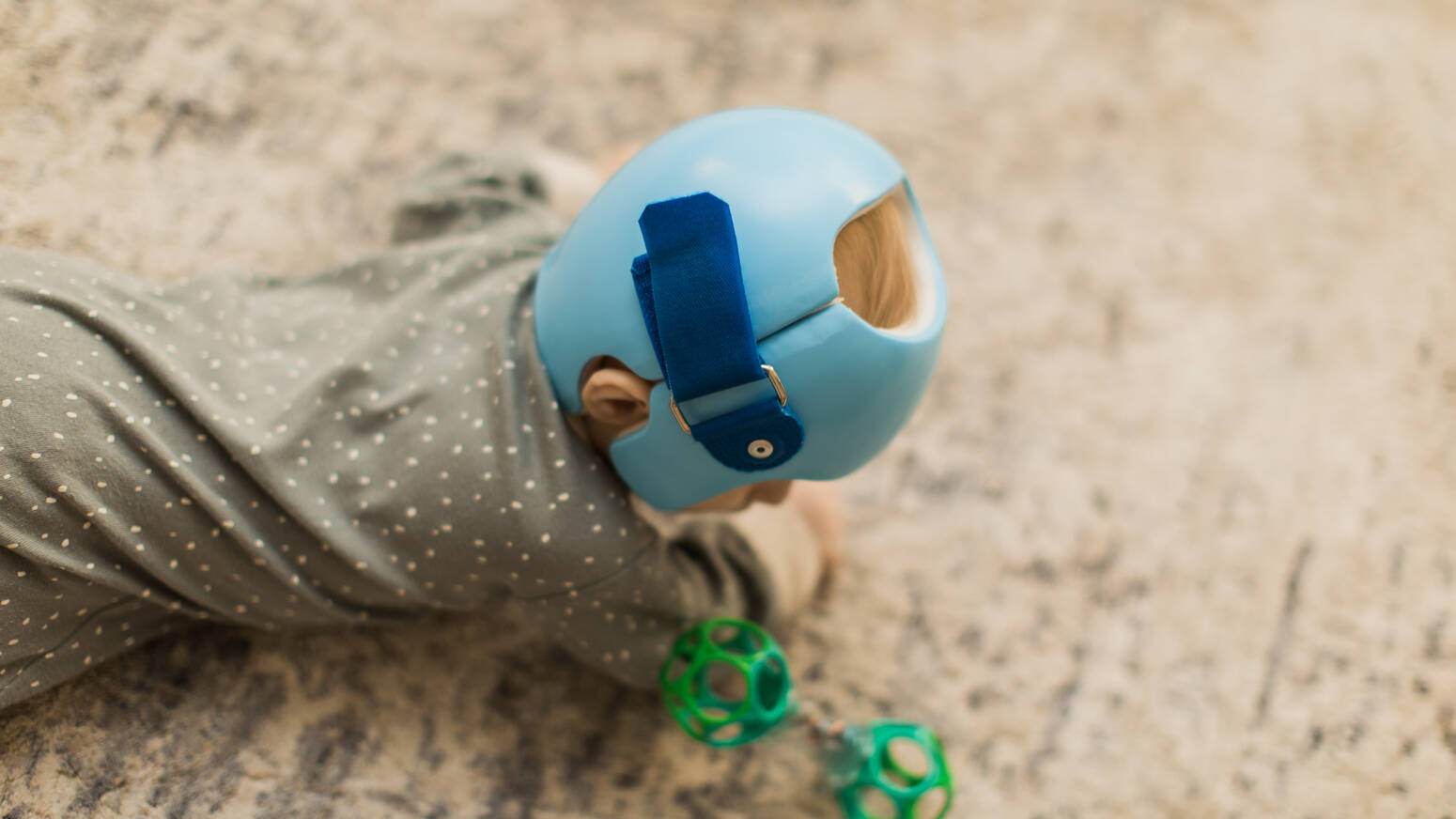 kid crawling on floor with helmet