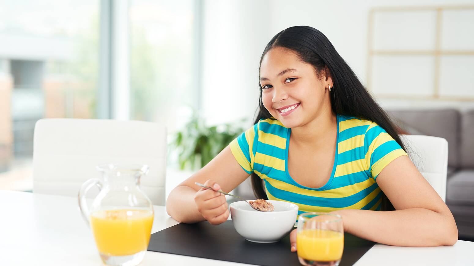 teen girl at dining table smiling