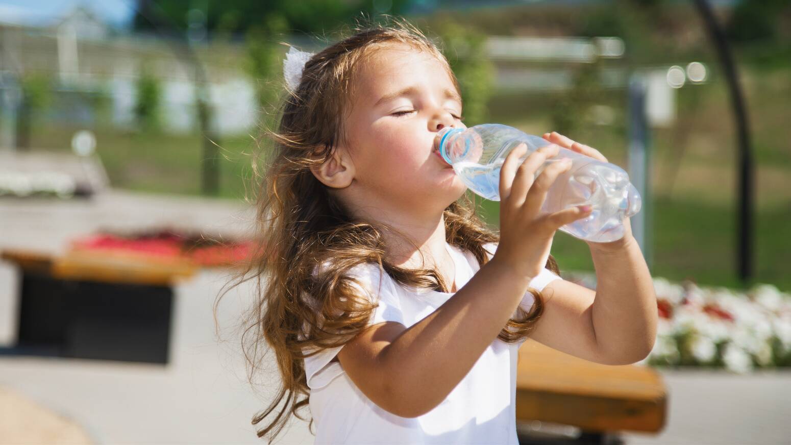 girl outside drinking water bottle