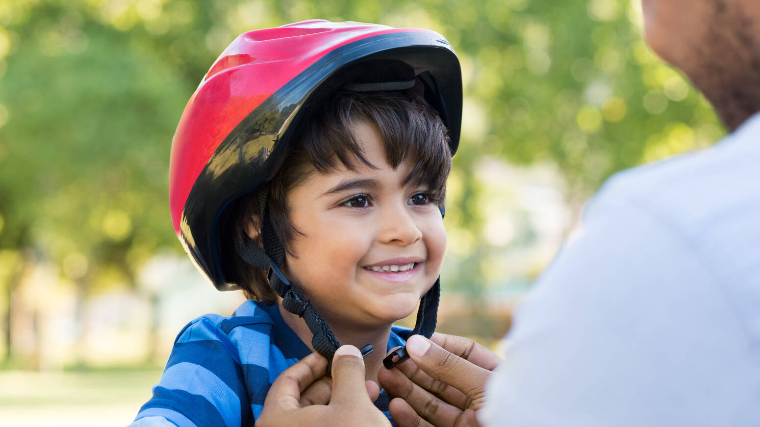 parent-putting-helmet-on-child