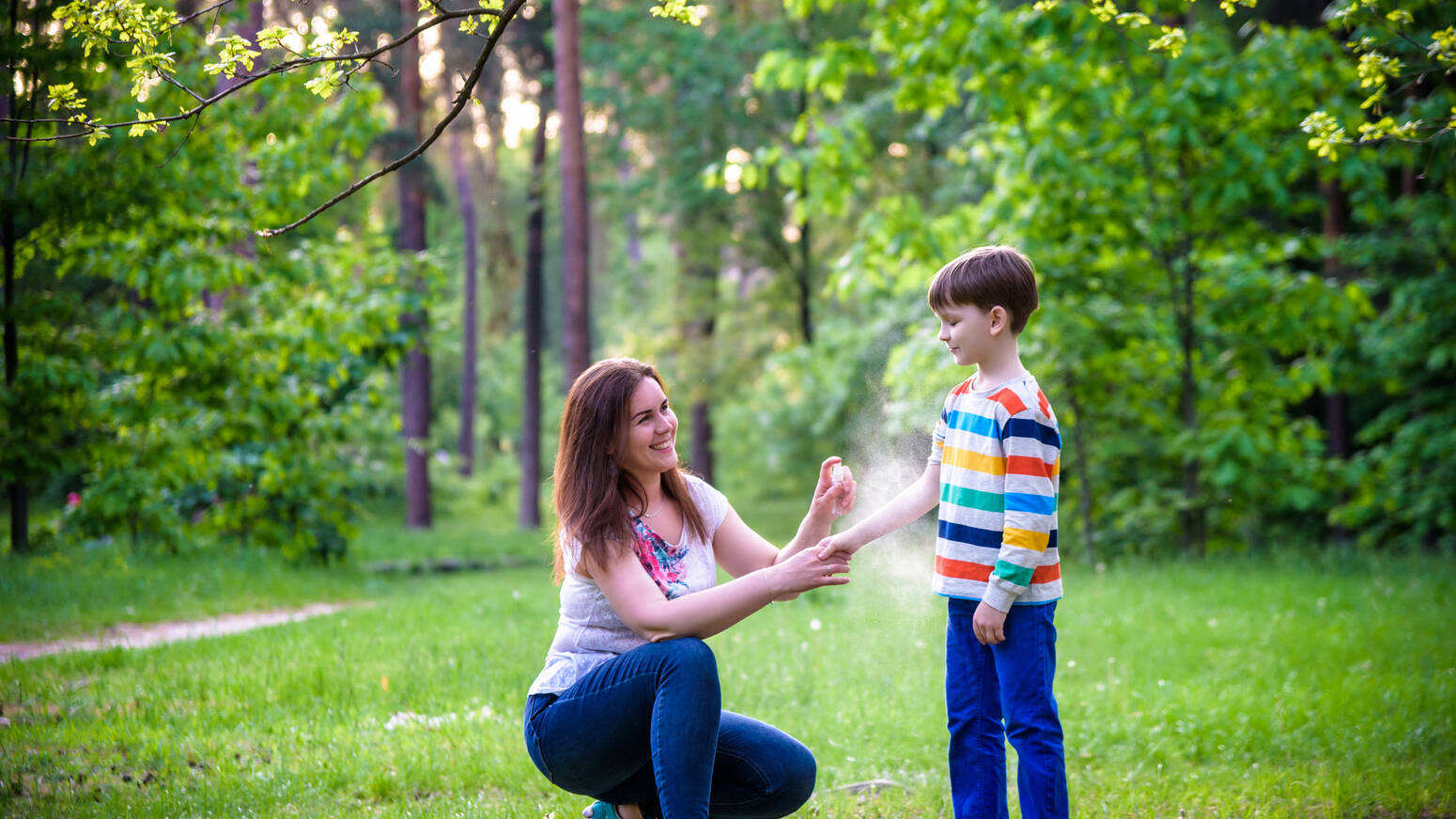Parent-applying-bug-spray-to-child