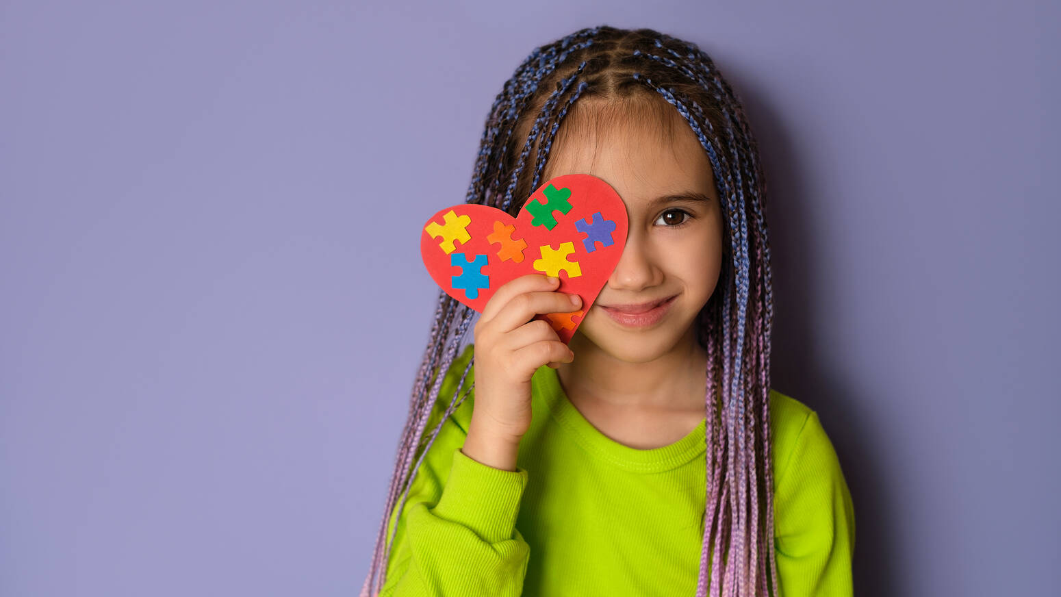 girl standing with autism awarness heart