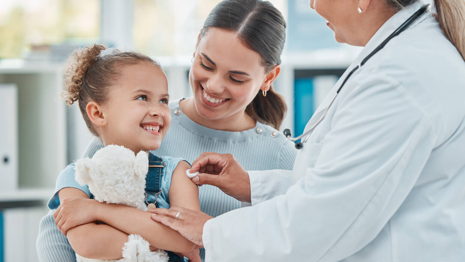 girl with mom smiling after vaccine
