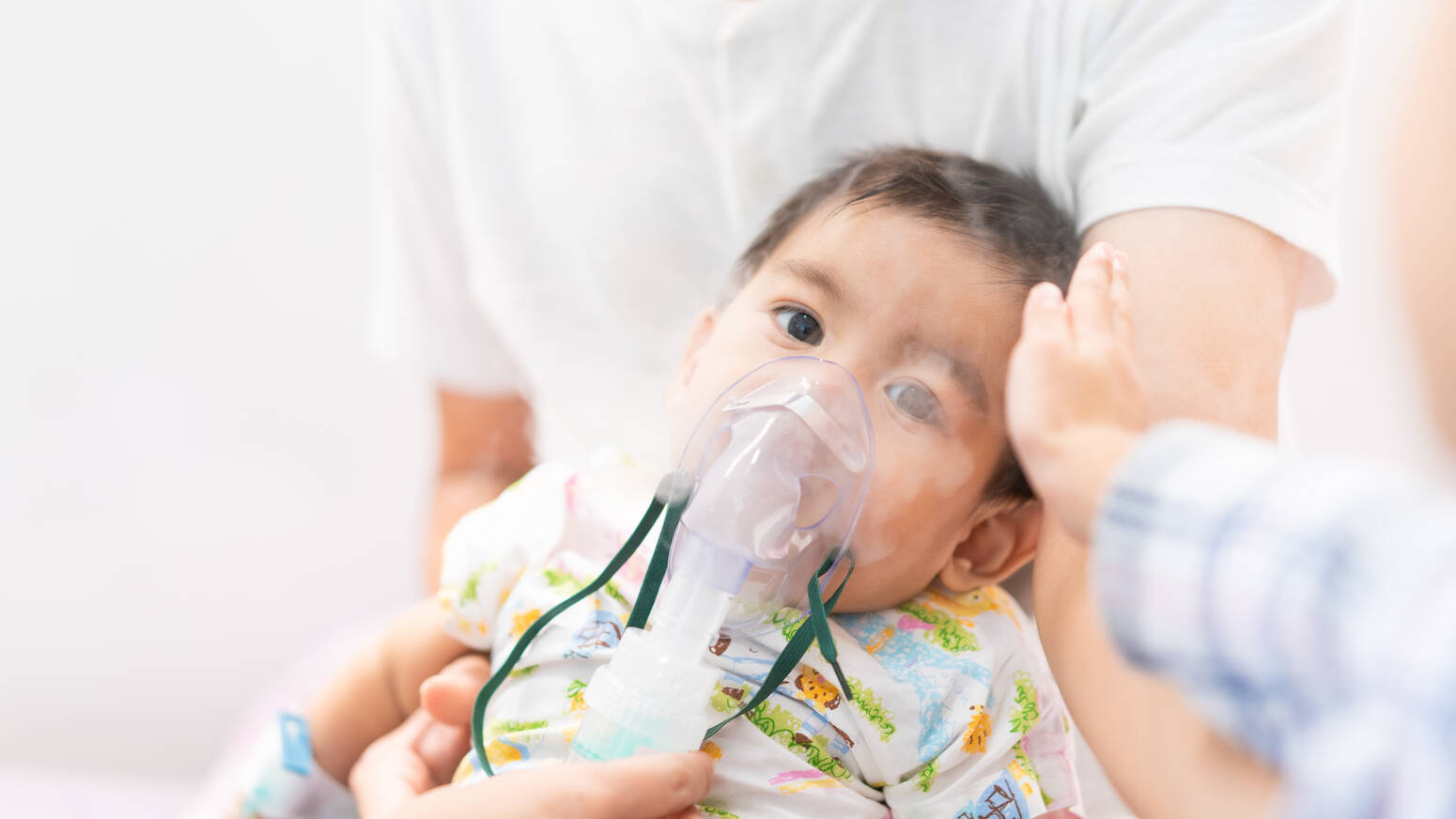 baby sitting with breathing mask