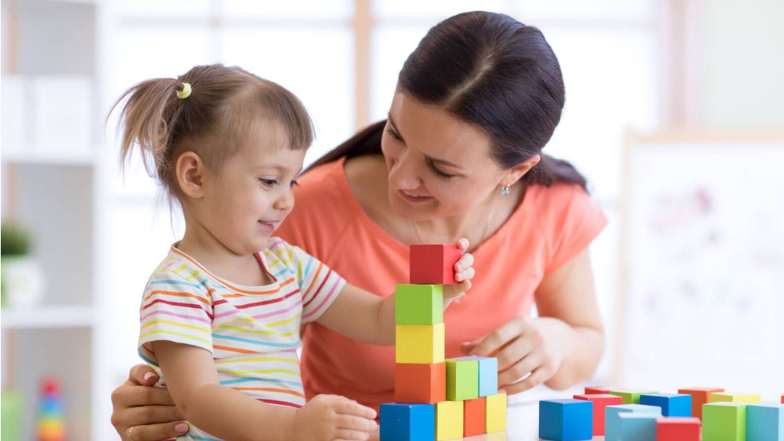 Kid and adult playing with stacking building blocks