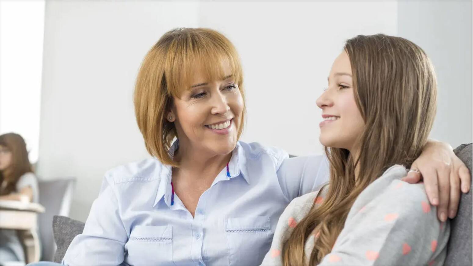 Mother and daughter talking mom arm wrapped around daughter