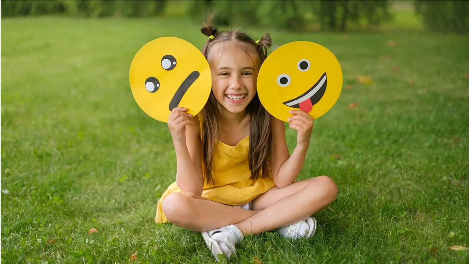 young girl playing with two discs one happy silly face other bleh face