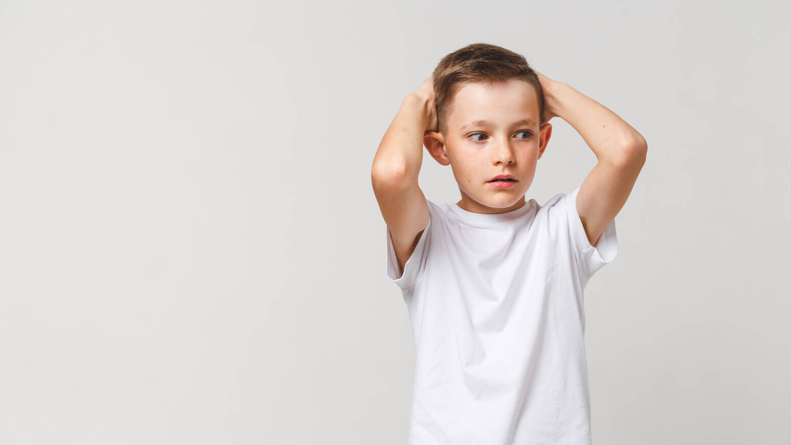 Young child hands over head stressed