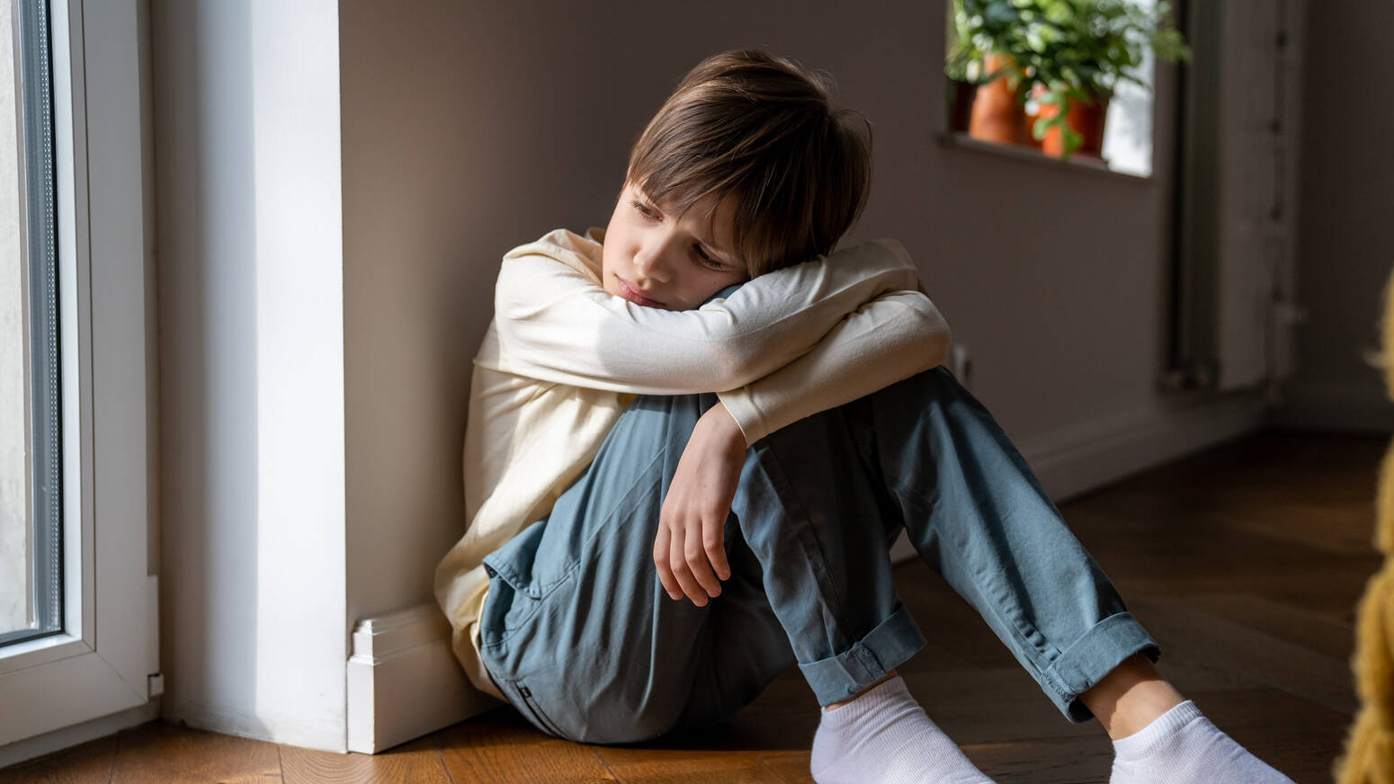 Child sitting on the floor arms crossed
