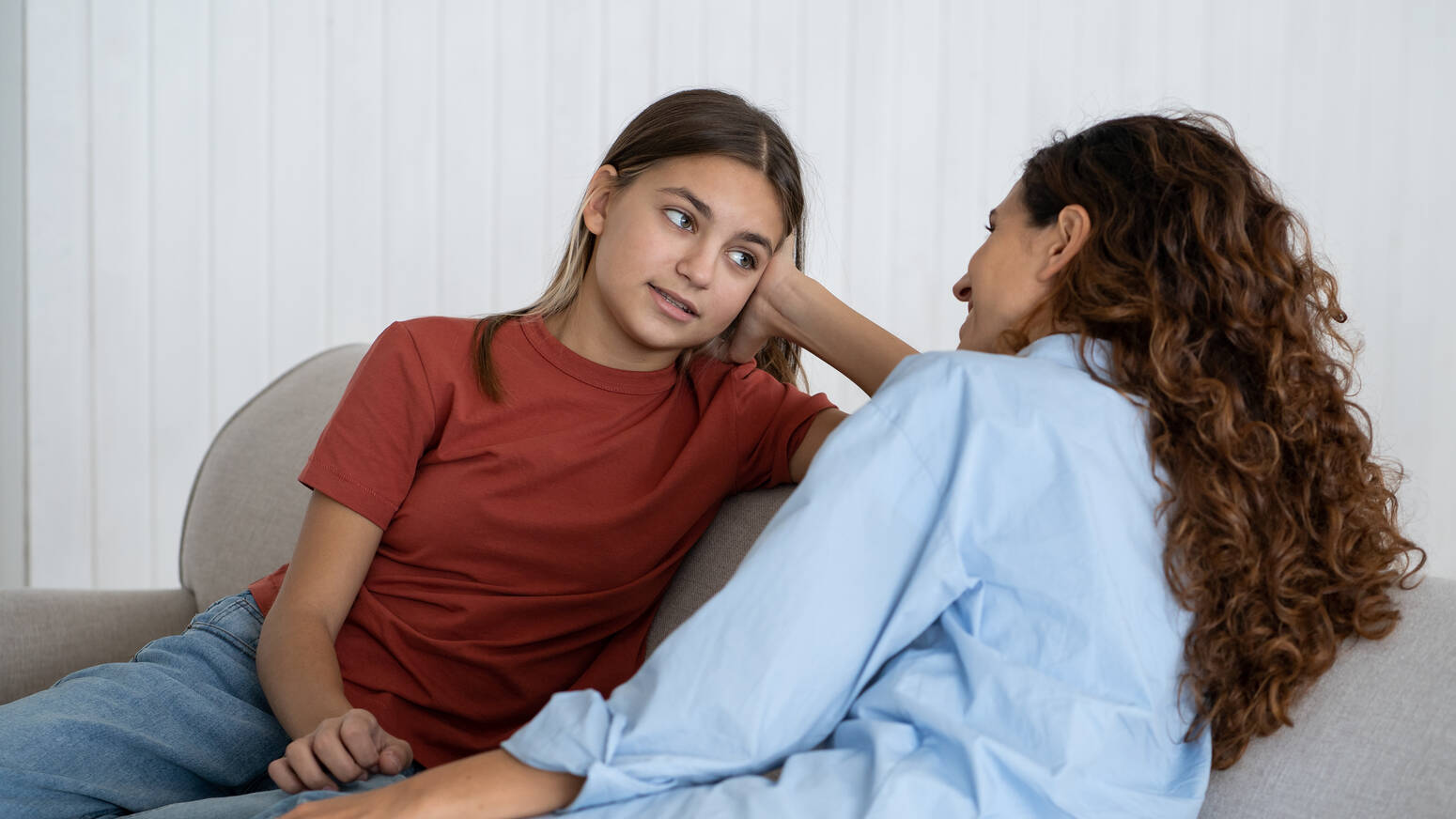 teen talking to adult on couch