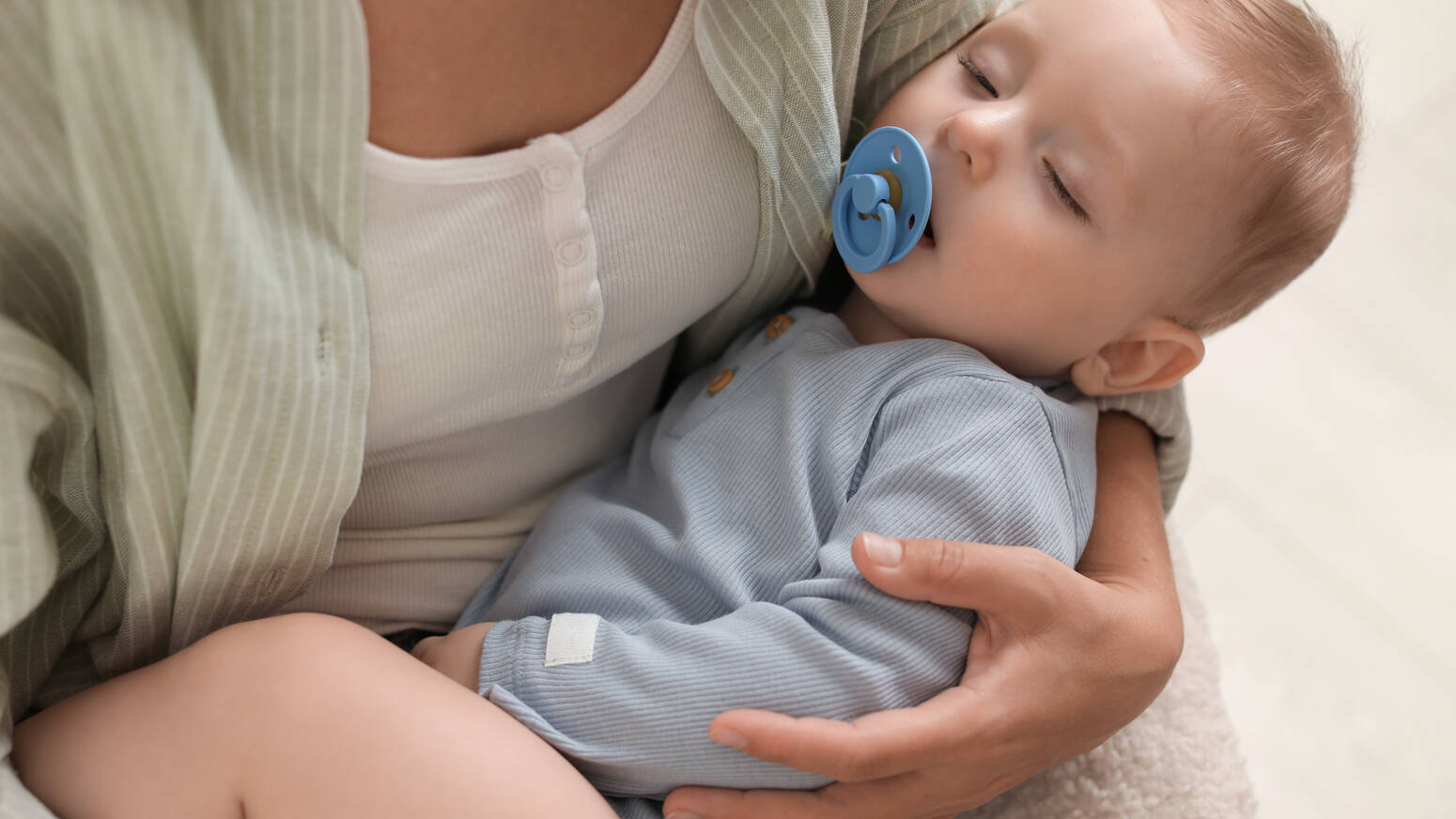 parent-holding-sleeping-baby