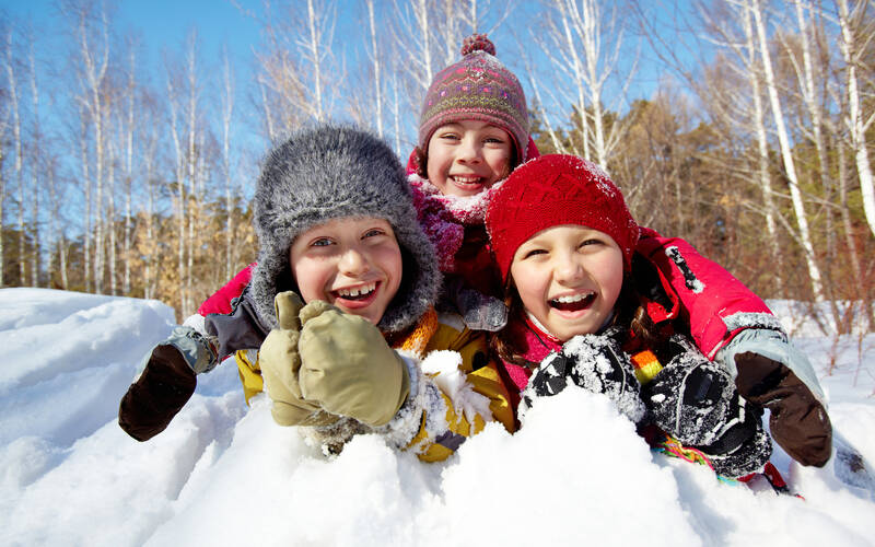 three kids play in snow
