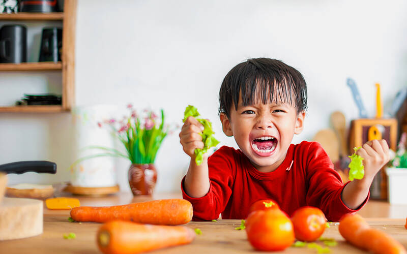 child-holding-vegetables-crying