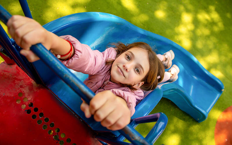 smiling girl holding onto slide