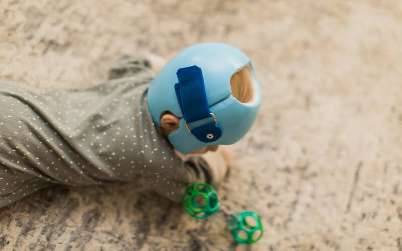 kid crawling on floor with helmet