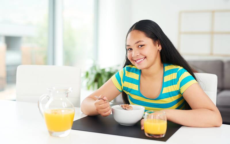 teen girl at dining table smiling