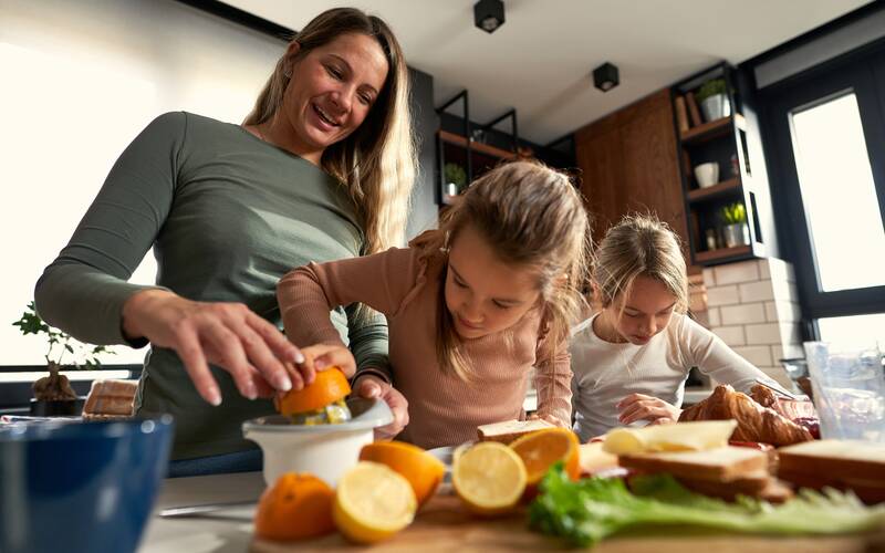 boy and girl cooking with mom in kitchen