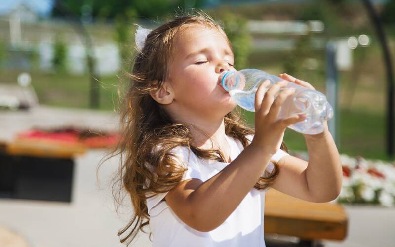 girl outside drinking water bottle