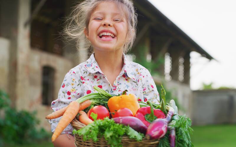 girl-smiling-with-vegetables