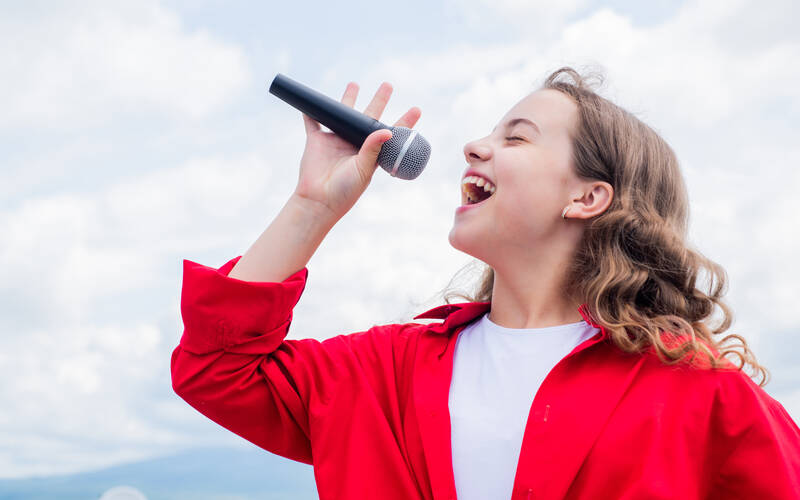 Person singing with mic in hand