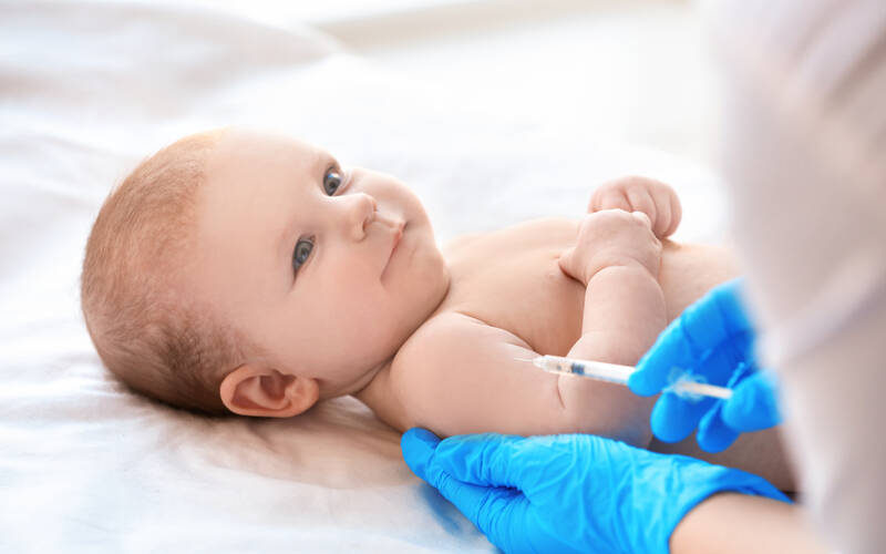 baby smiling getting vaccine