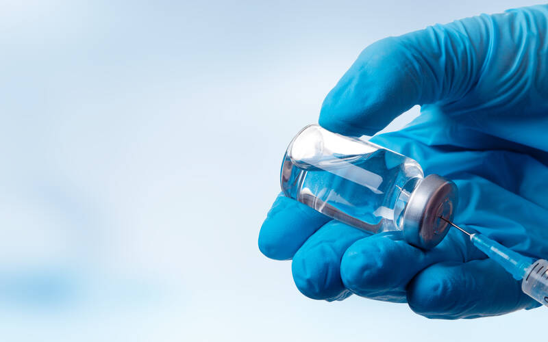 hand with glove on using vaccine