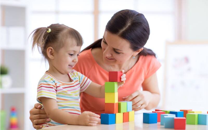 Kid and adult playing with stacking building blocks