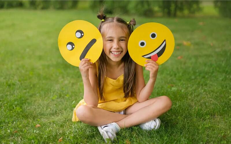 young girl playing with two discs one happy silly face other bleh face