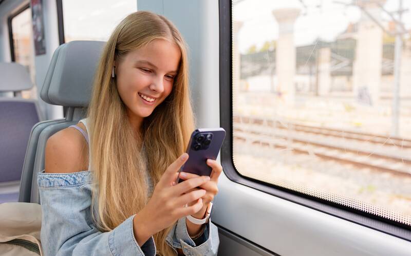 teen on train on phone