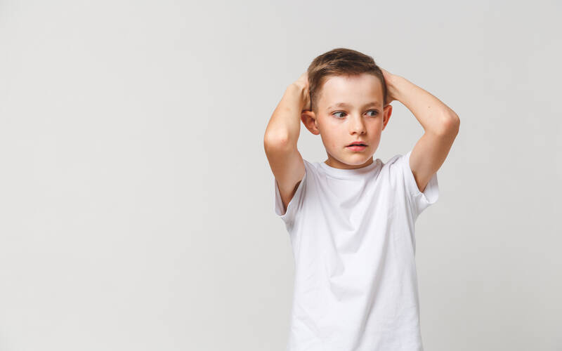 Young child hands over head stressed