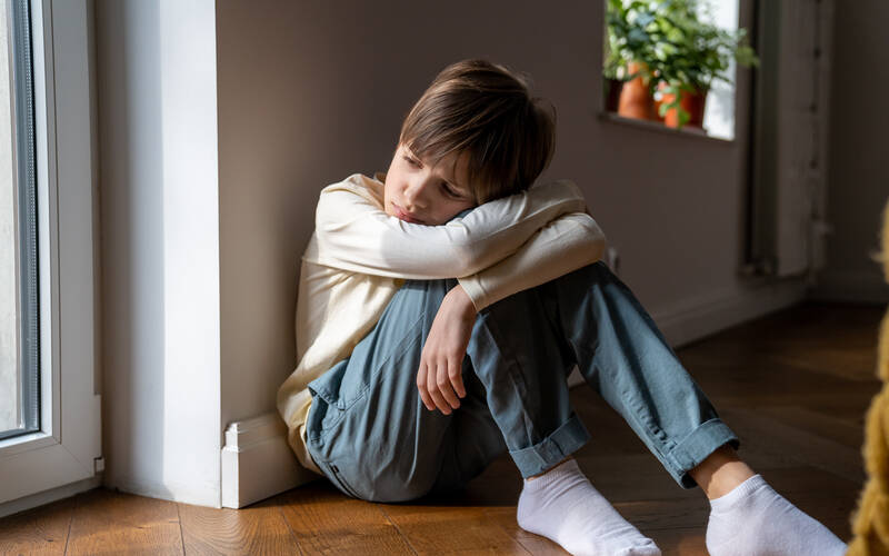 Child sitting on the floor arms crossed