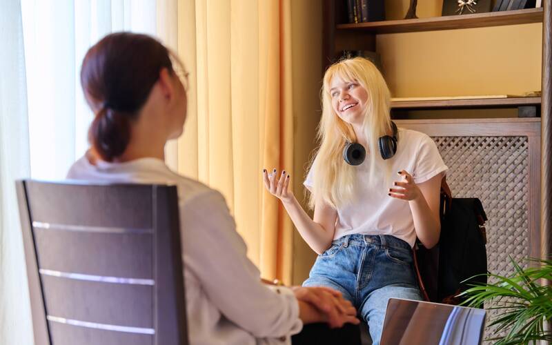 teen sitting talking to someone understanding