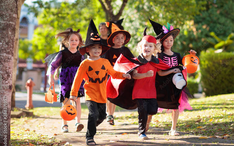 children on sidewalk in halloween costumes