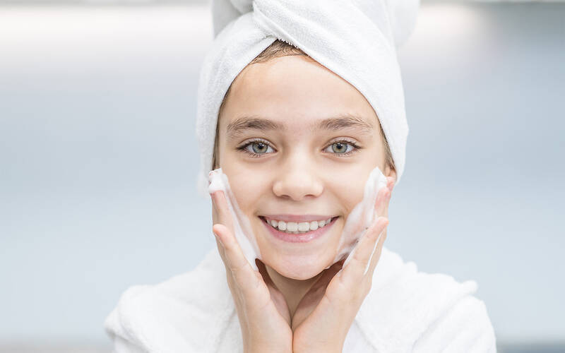 Young girl washing her face