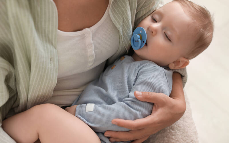 parent-holding-sleeping-baby
