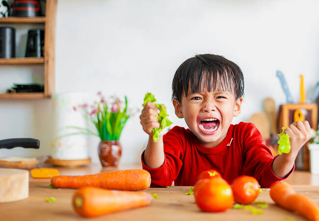 child-holding-vegetables-crying