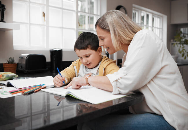 mom and son sitting at table doing schoolwork