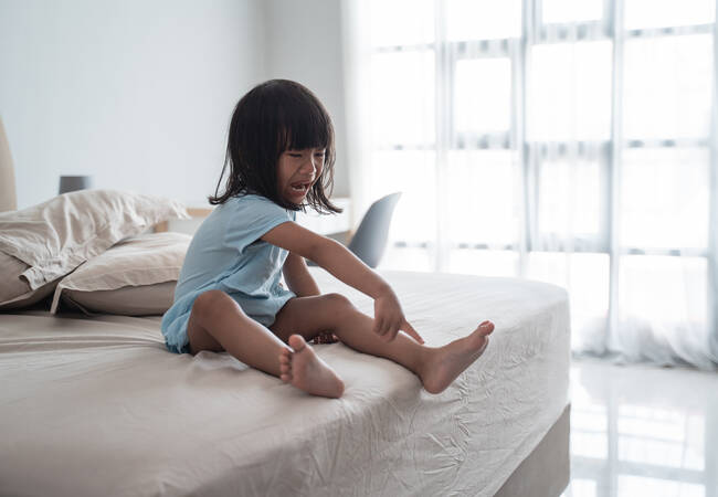 girl on bed throwing tantrum