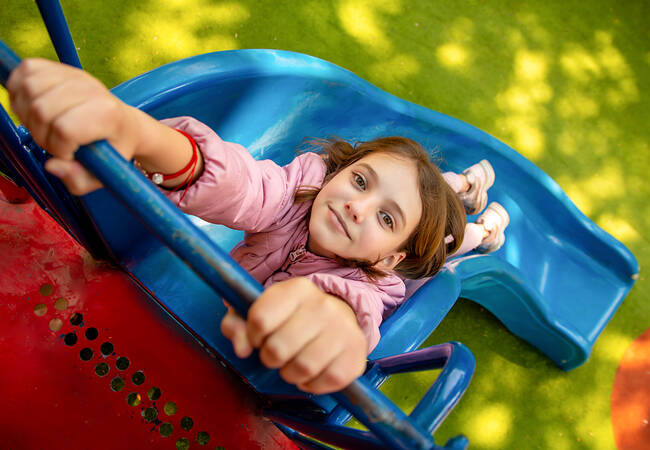 smiling girl holding onto slide