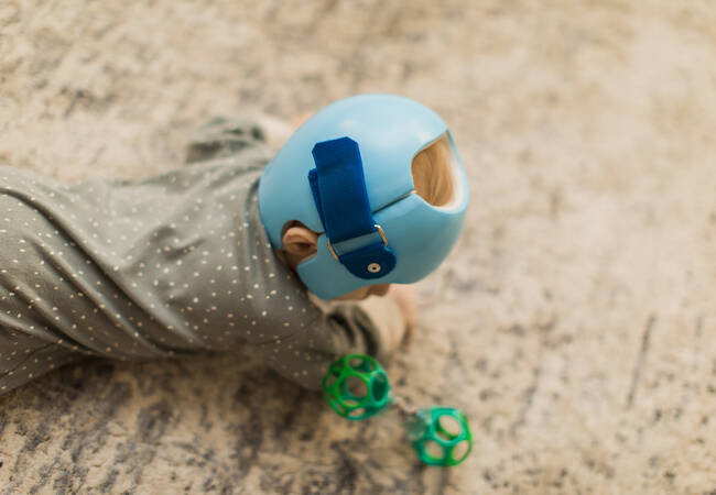 kid crawling on floor with helmet