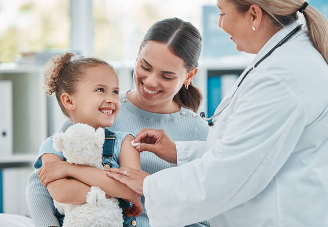 girl with mom smiling after vaccine