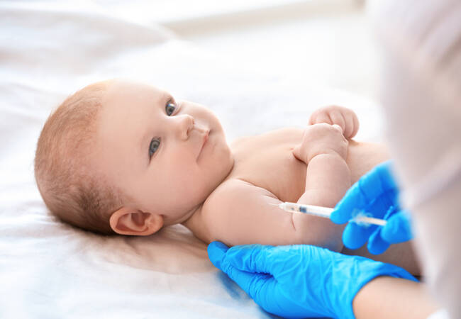 baby smiling getting vaccine