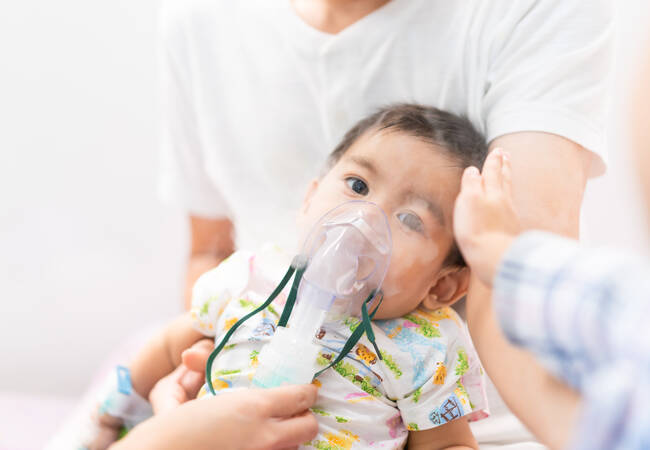 baby sitting with breathing mask