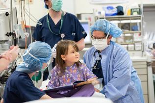 Girl and providers in an operating room
