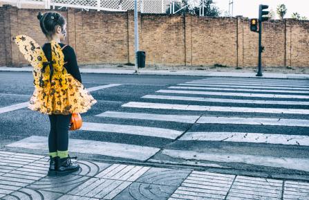 Photo of young girl waiting to cross a street.
